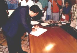 Foto do 1º Governador do Banco de Cabo Verde, Corentino Virgílio Santos, assinando o termo de posse